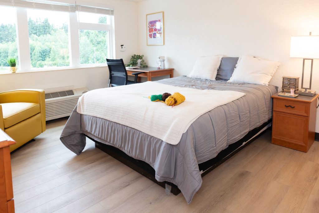 A bedroom with a grey bed at Sheila Stanton Place.