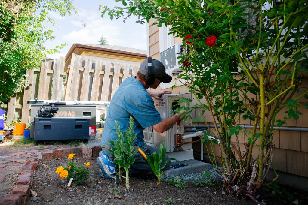 A worker installs a heat pump.