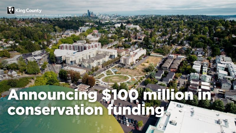 Aerial photo of Cheryl Chow Park with Seattle skyline in back reads "announcing $100 million in conservation funding"
